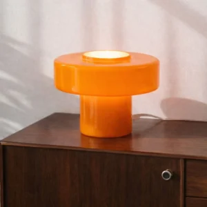 Lampe à poser champignon de couleur orange translucide au design rétro des années 70 posée sur un buffet.