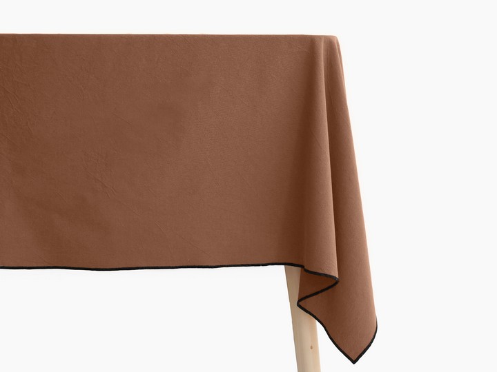 Nappe HONO Cognac posée sur une table, sur fond blanc